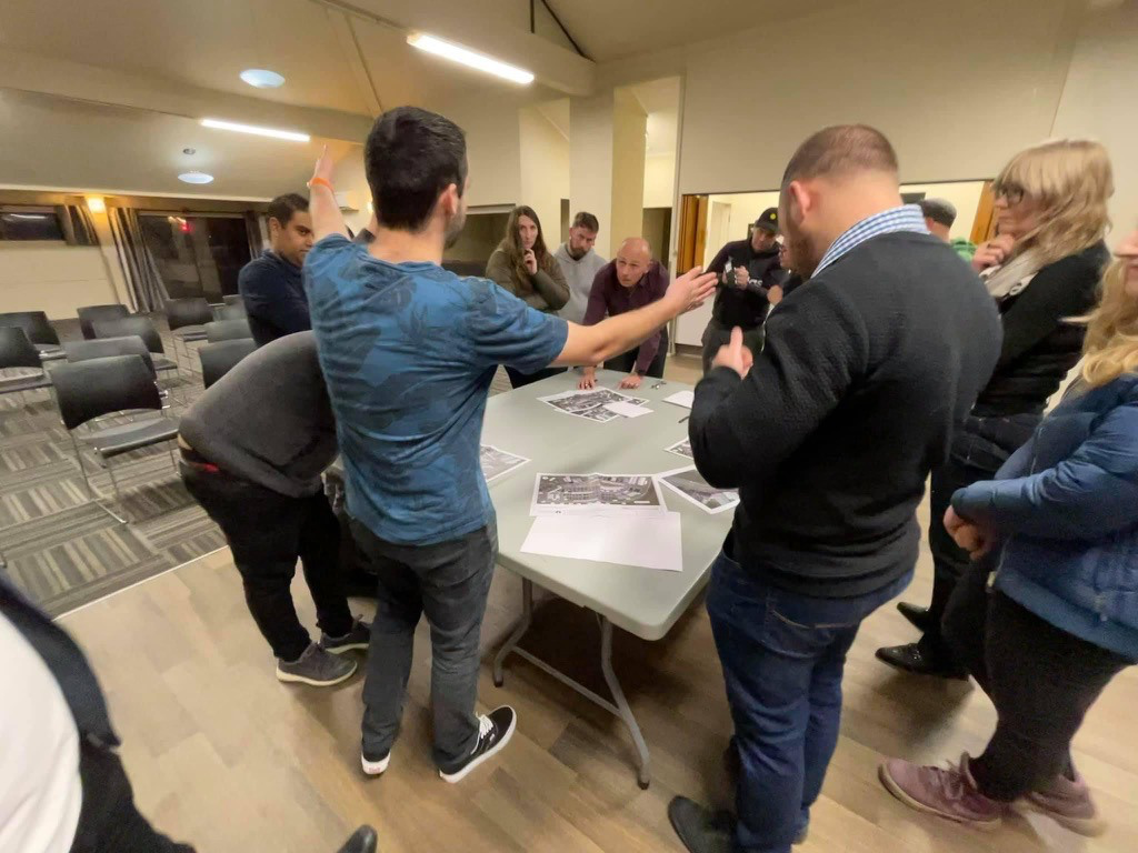 Cody Cooper with arms stretched while residents look on at a residents meeting with Council staff