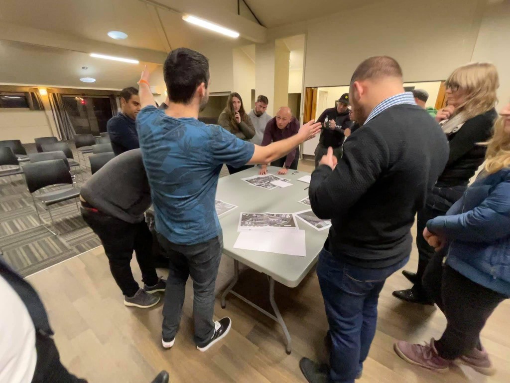 Cody Cooper with arms stretched while residents look on at a residents meeting with Council staff
